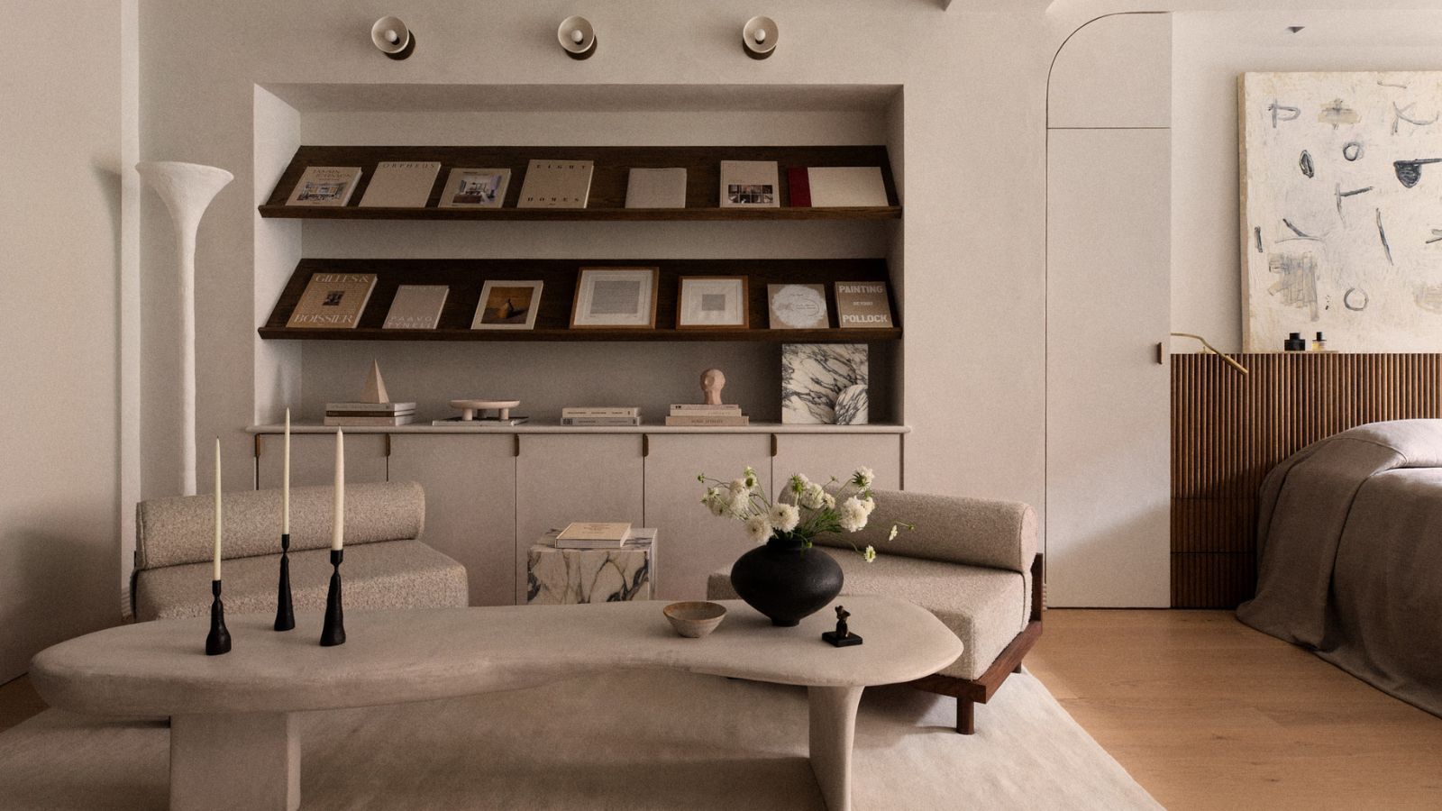 Minimalist style living room with bookshelf, curved coffee table and low armchairs
