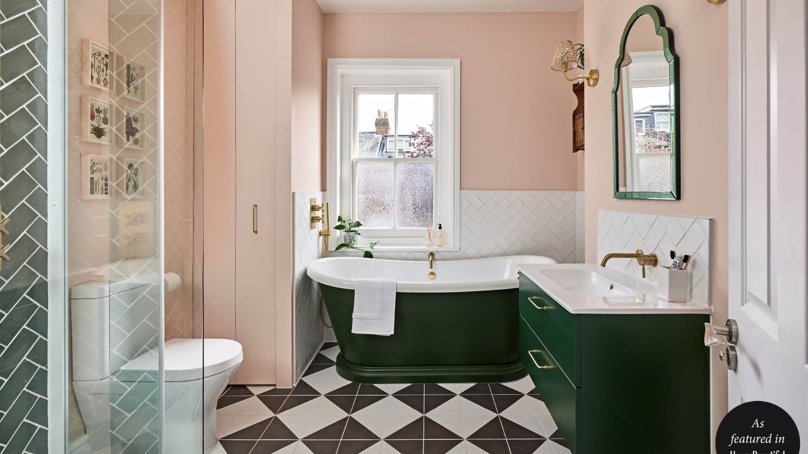 Pink bathroom with dark green bath and cabinetry and checkerboard black and white flooring