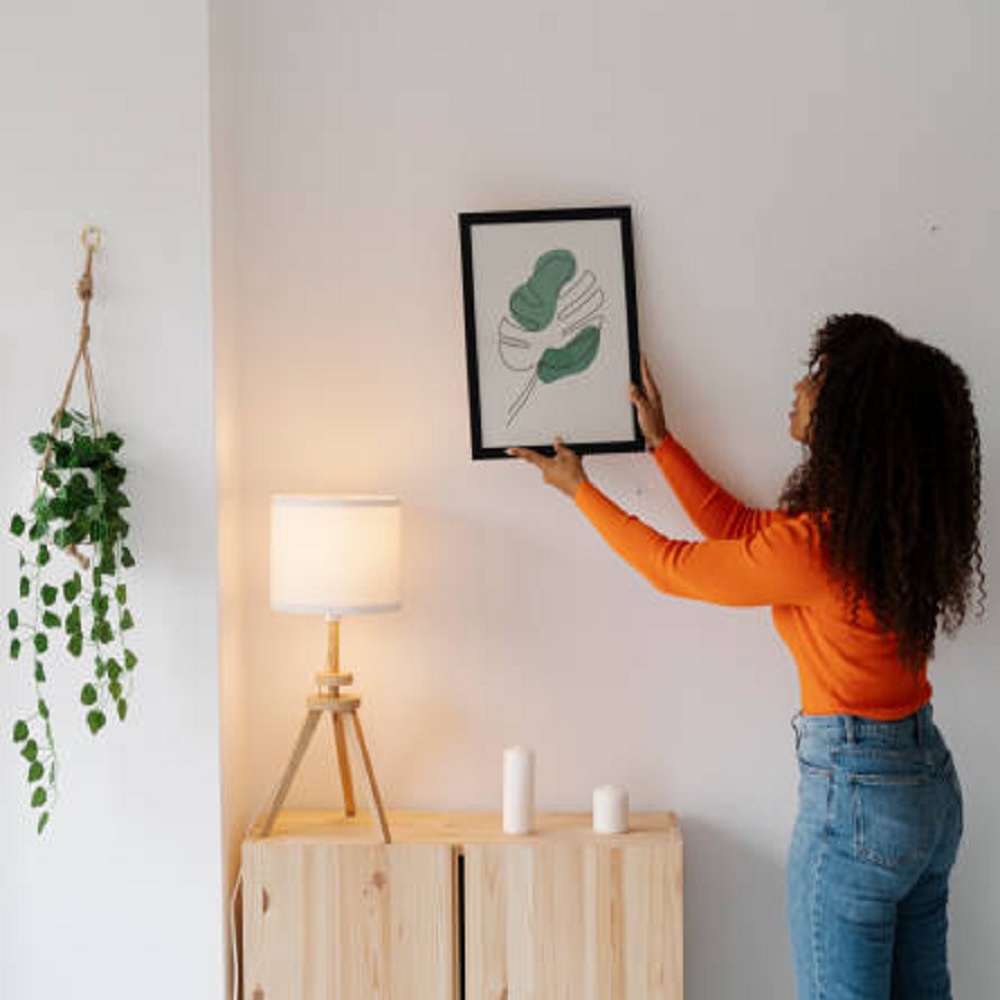 Woman hanging a photo on a wall