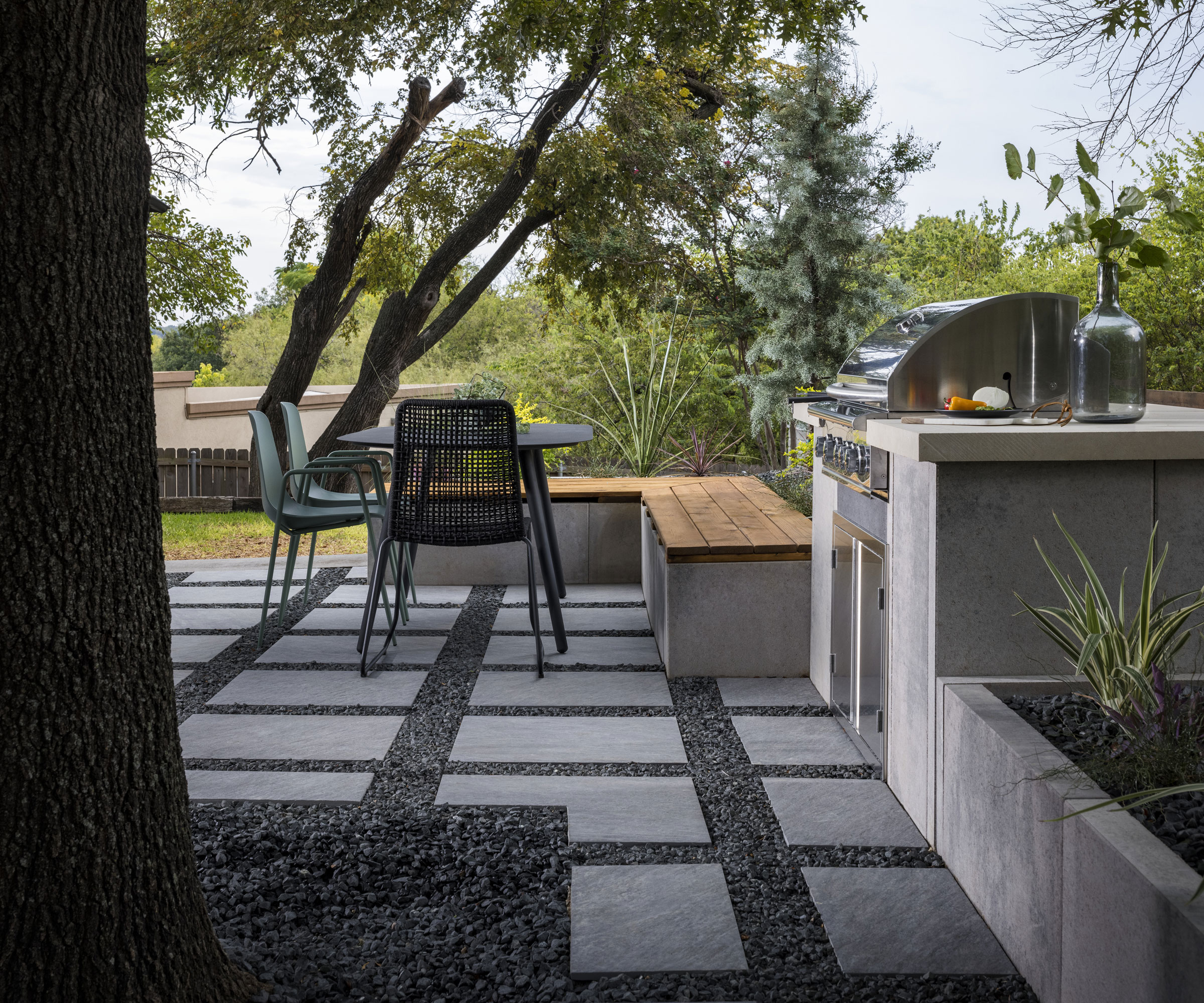 L-shaped bench and outdoor kitchen area with table and chairs