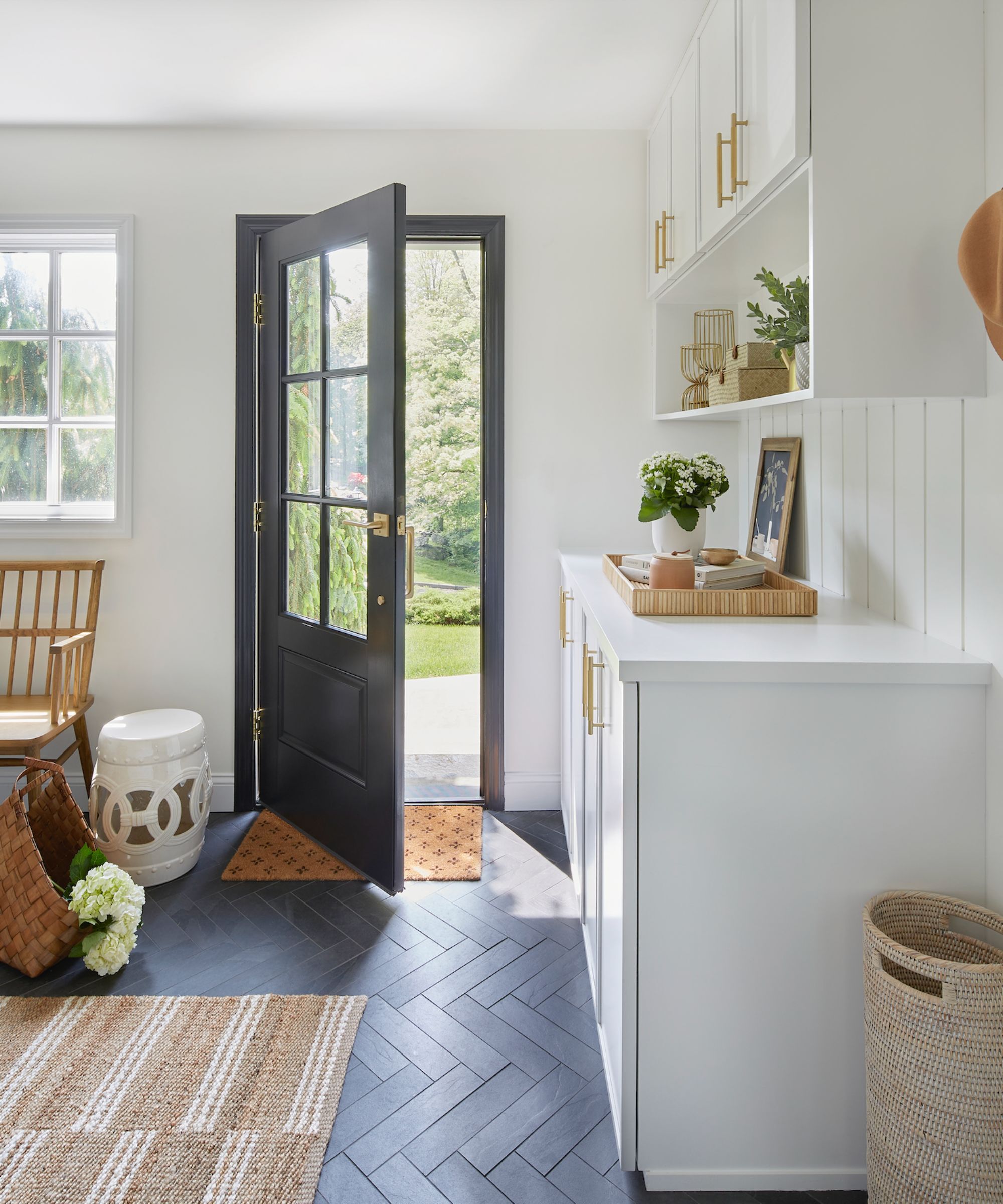 A doorway from a kitchen diner to the garden, the walls and cabinets are painted in Simply White, Benjamin Moore
